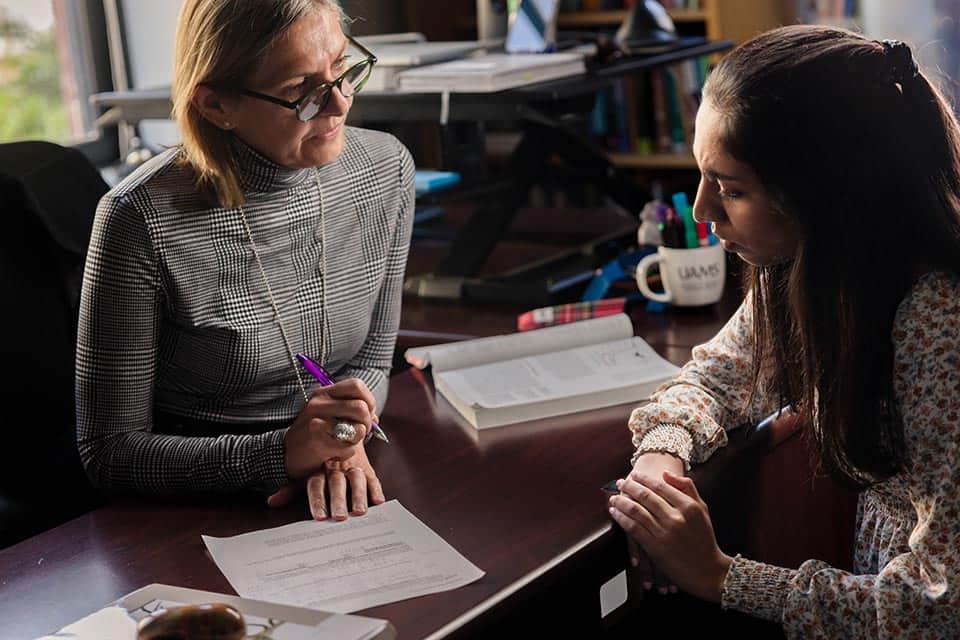 High schools and coordinators An advisor speaks with a student in her office.