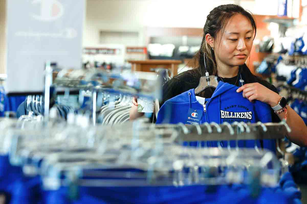 SLU apparel Female student wearing SLU Gear shopping at the bookstore