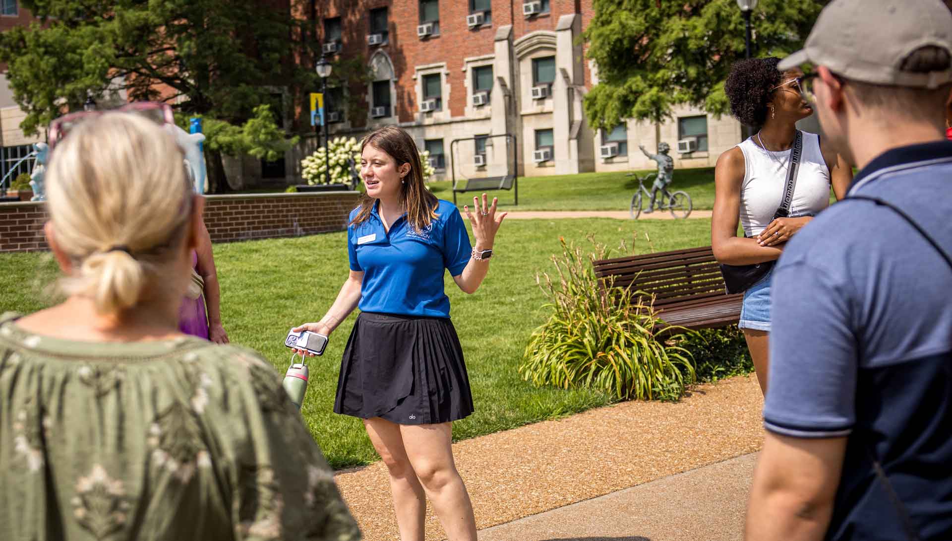 A student tour guide leads visiting families around campus