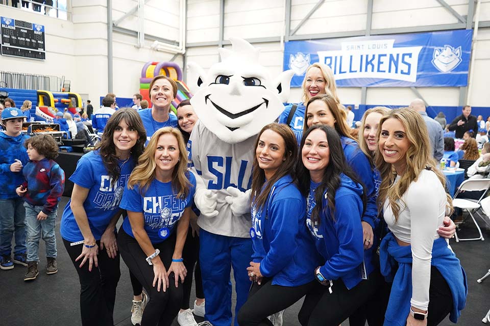 Billiken Fan Fest A group of women wearing SLU shirts pose for a photo with the Billiken.