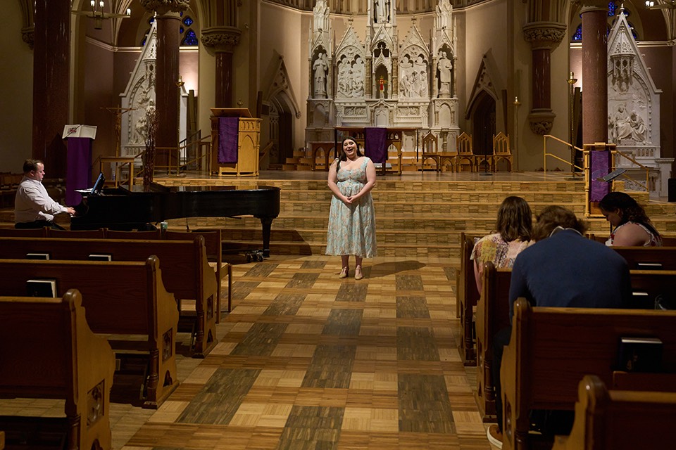 A singer stands in a chuch Music major Sarah Hymes performs in College Church