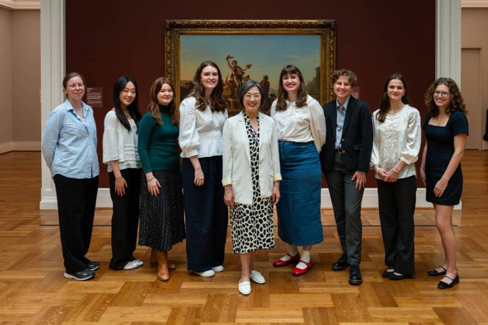 a group of people stand in an art museum