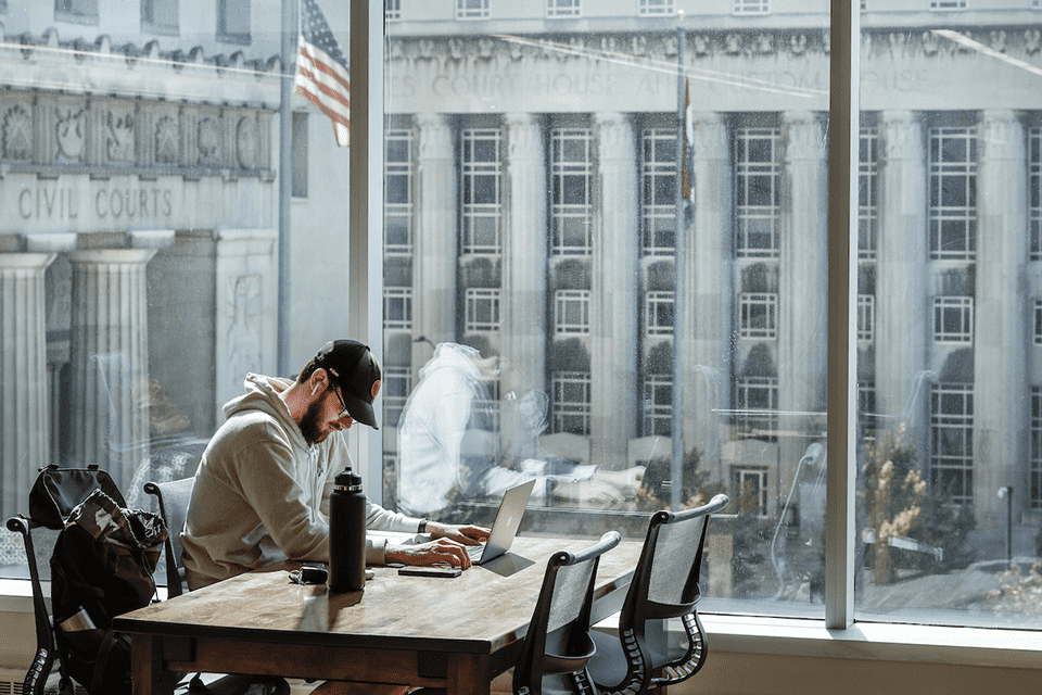 Law School study Male student studies at desk in library. Civil courts building can be seen outside the window.