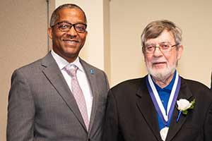 Frank Magiera Frank Magiera poses for a photo with the School of Science and Engineering dean while wearing a medal.