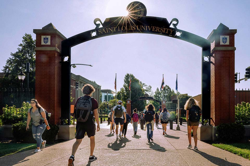 Students on Campus Students walk under an archway on campus.