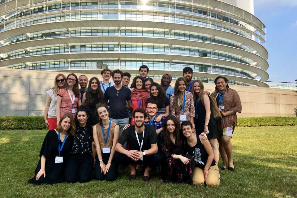 Raymond Moylan Raymond Moylan with a large group posing outside a building on a clear day