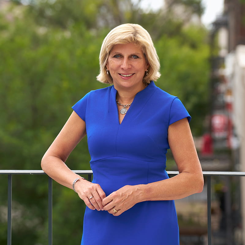 A woman in a blue dress poses for a photo.