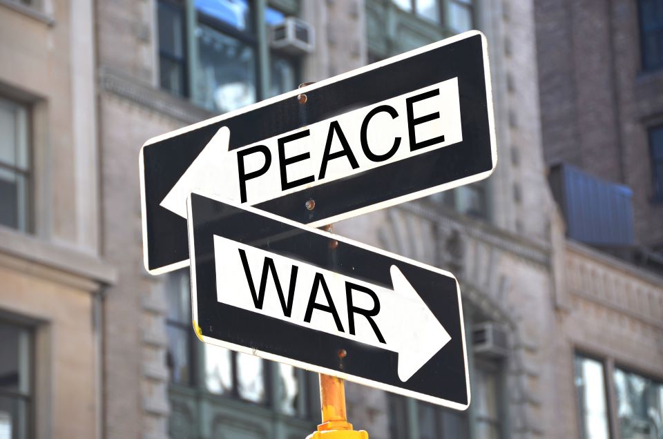 Contemporary Challenges in International Humanitarian Law: Is there Hope for the International Order? graphic of a street sign that says peace and war