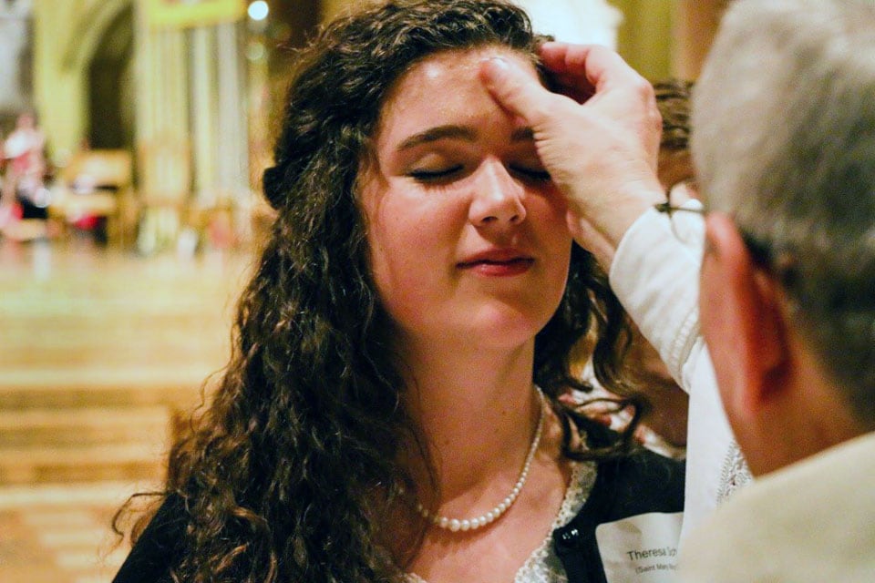 Ash Wednesday A Mass participant receives ashes on her forehead from a priest.