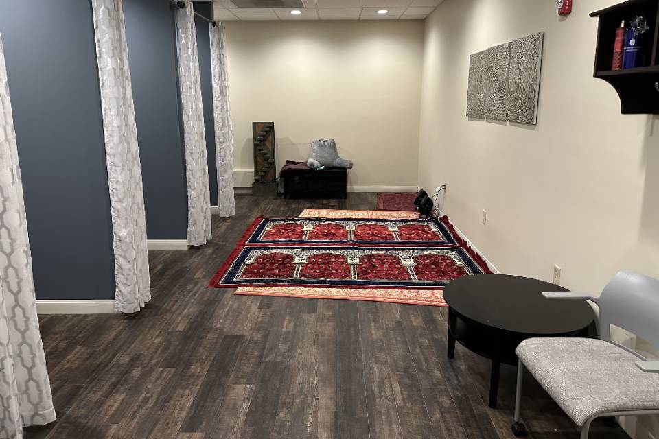 School of Medicine Interfaith space A long narrow room with alcoves on each side with curtains. There are prayer rugs lined up on the floor, as well as some chairs and cushions.