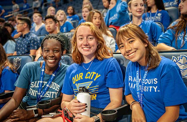 New SLU students just beginning their freshman year Three new freshman students sitting in the stands at Chaifetz Arena at convocation