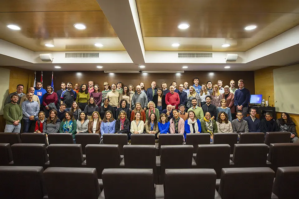 Members of the SLU-Madrid Staff Members of the SLU-Madrid Staff standing and sitting in several rows in an auditorium.
