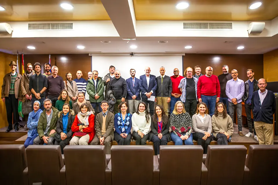 Faculty - SLU-Madrid campus Faculty members pose while standing and sitting on the podium in an auditorium.
