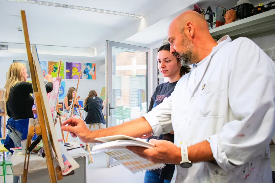 Visual and Performing Arts Student wearing long skirts and standing in rows dance with shawls during a flamenco class.