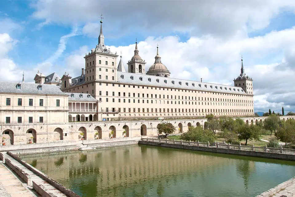 The Escorial Monastery Exterior shot of a monastery with a large pond in the patio.