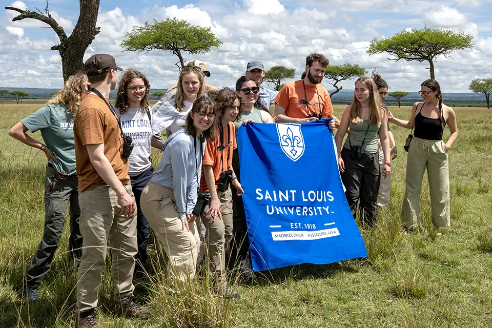 Kenya trip Landscape with a group of students in a grassy savanna.