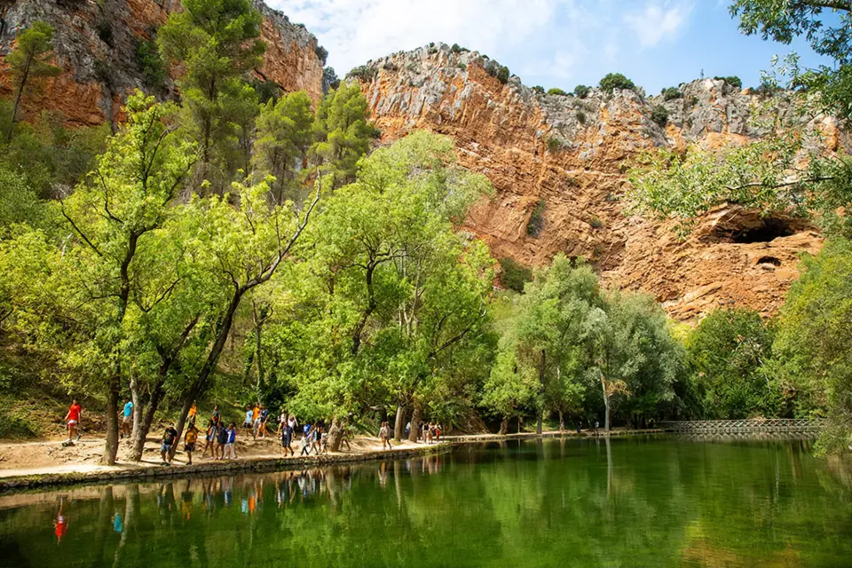 Monasterio de Piedra People walking along a river between mountains.