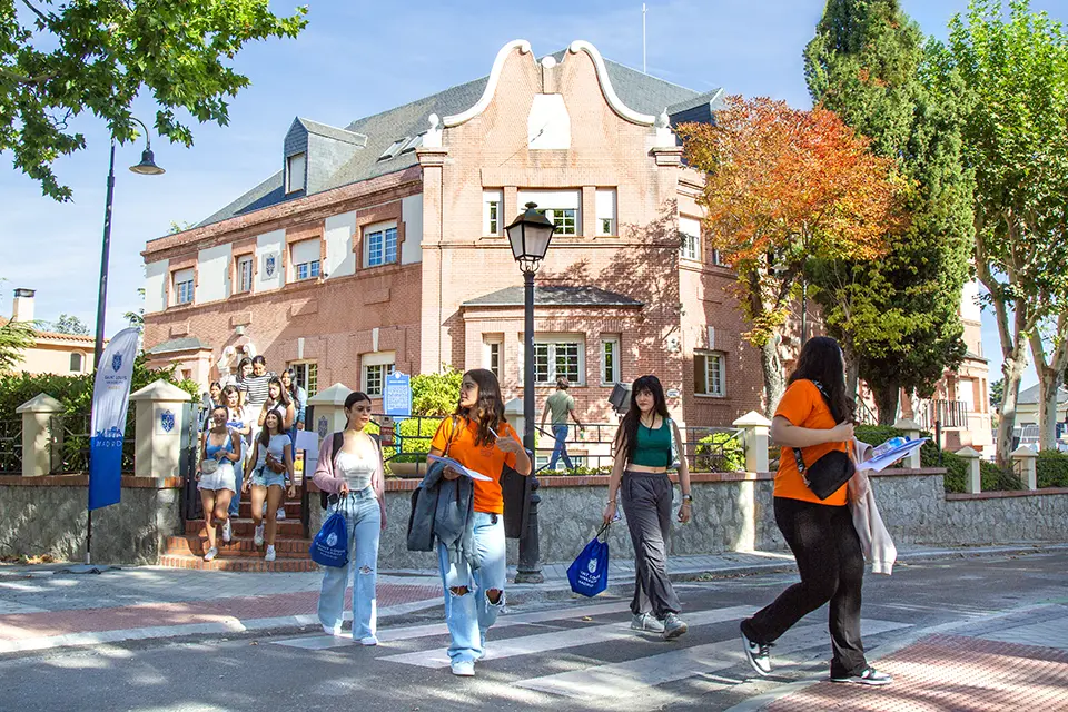 Registrar Students walking down the street in front of the SIH building.