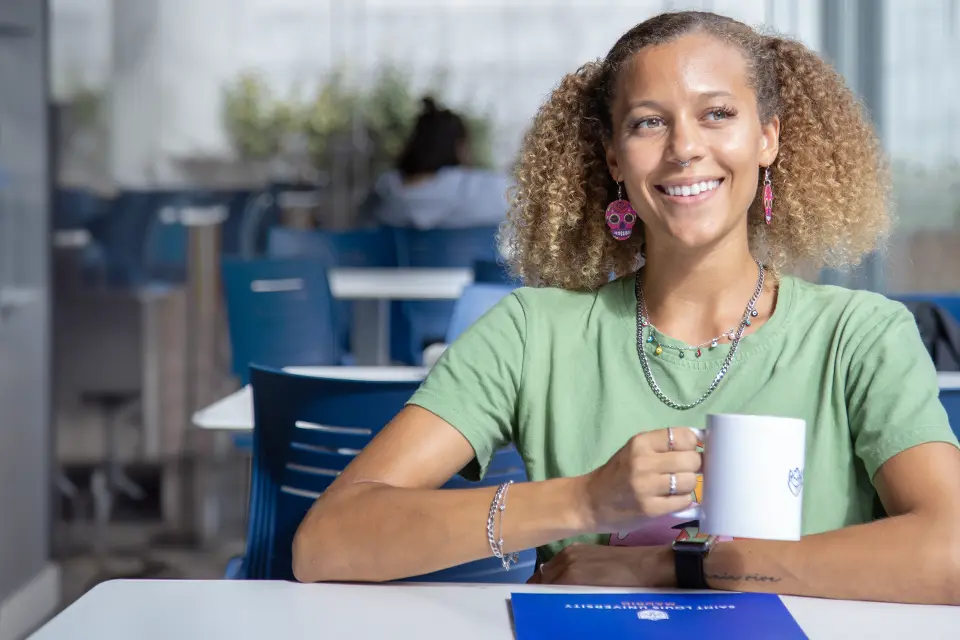 Student having a coffee sitting in the student lounge. Student having a coffee sitting in the student lounge.