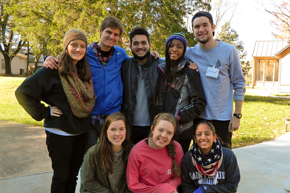 A group prepares for a retreat A group of 8 students pose for a photo outdoors while preparing for a retreat.