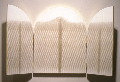 Susan Schwalb, Sacred Land IV, 1991. MOCRA collection. An artwork by Susan Schwalb titled Sacred Land IV. Two panels unfold on hinges from a central, tablet-shaped panel. The three panels are painted white and covered with a dense network of fine lines hand-drawn in silverpoint and gold.