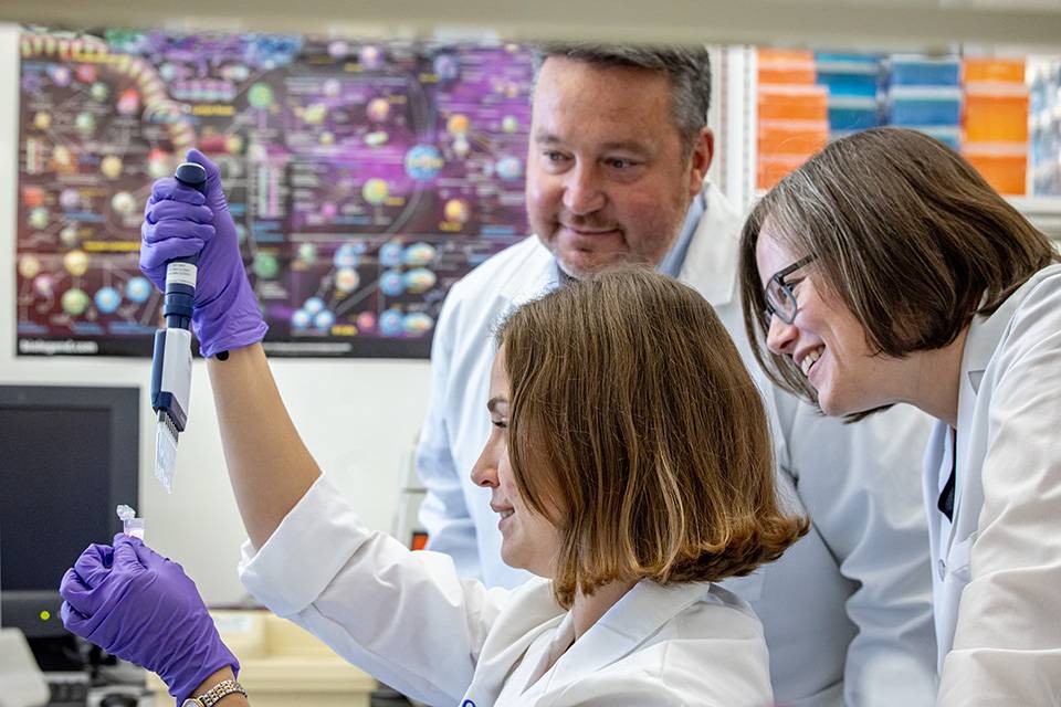Stella Hoft, left, performs single-cell RNA sequencing on May 24, 2023, as Richard DiPaolo, Ph.D, and Elise Alspach, Ph.D, right, watch on May 24, 2023. A photo of three people in a lab.