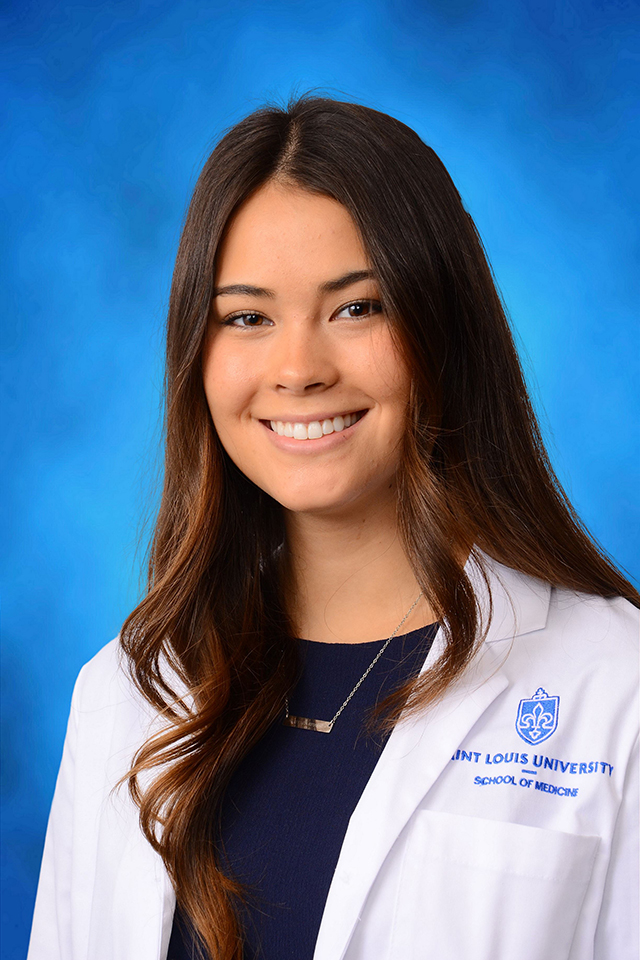 Megan Halloran Megan Halloran poses for a headshot against a blue background.