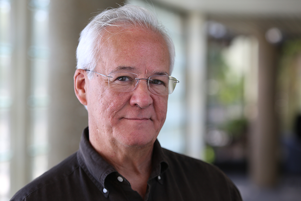 Ricardo Wray Professor Ricardo Wray stands in a hallway on Saint Louis University's campus smiling at the camera.