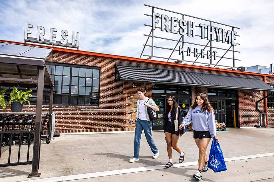 2022 Midtown Students leave Fresh Thyme Market while carrying shopping bags.