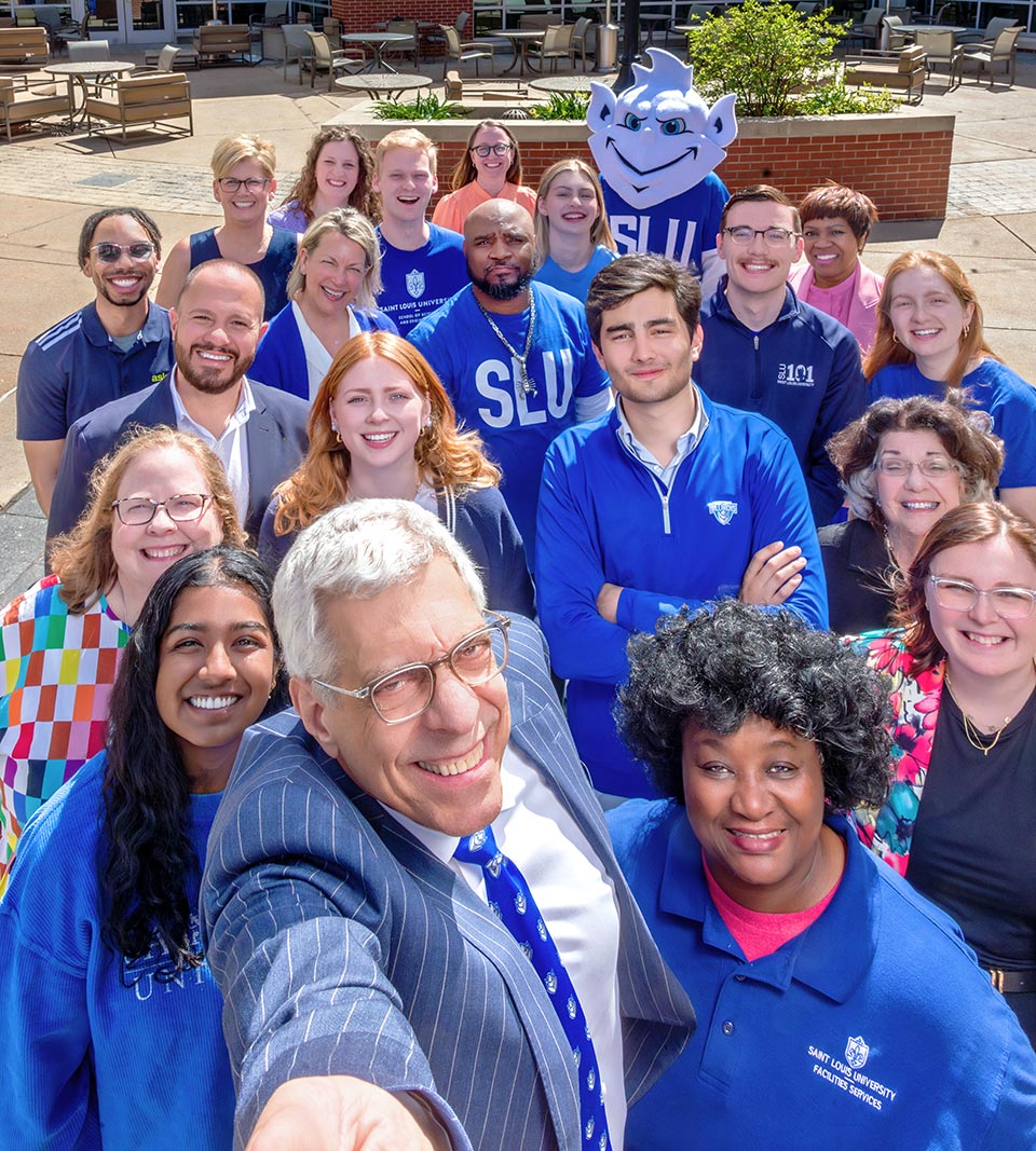 President Emeritus Dr. Fred Pestello poses for a selfie outside of Grand Hall with numerous students, staff and faculty behind him.